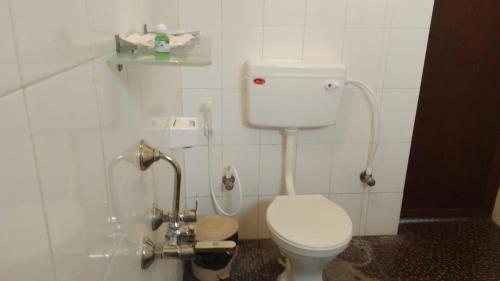 a white bathroom with a toilet and a sink at The Wild Fo'rest Resorts in Masinagudi