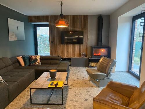 a living room with a couch and a fireplace at Maison de vacances la Grange 20 min de namur 