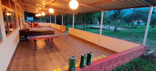 um pátio exterior com piso em madeira e uma mesa em The Wild Fo'rest Resorts em Masinagudi