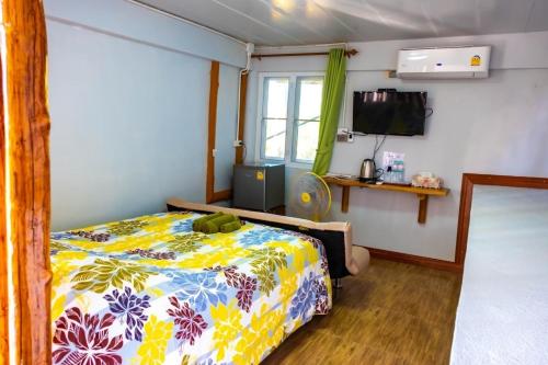 a bedroom with a bed and a television in it at One khaokho homestay in Khao Kho