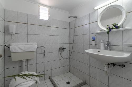 a white bathroom with a sink and a mirror at Krinos apartment 4 in Kharadhiátika