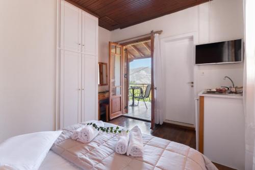 a bedroom with a bed and a kitchen with a balcony at Krinos apartment 4 in Kharadhiátika