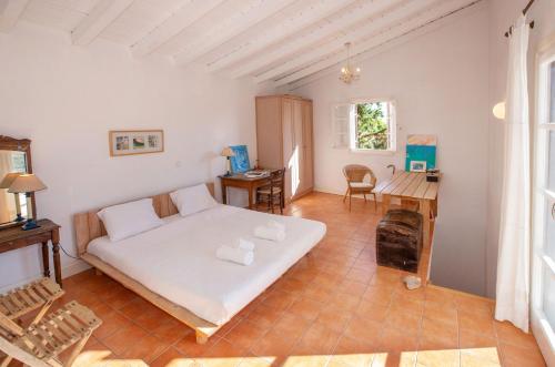 a bedroom with a bed and a desk in a room at Roxanne's Olive Grove House in Kranidi