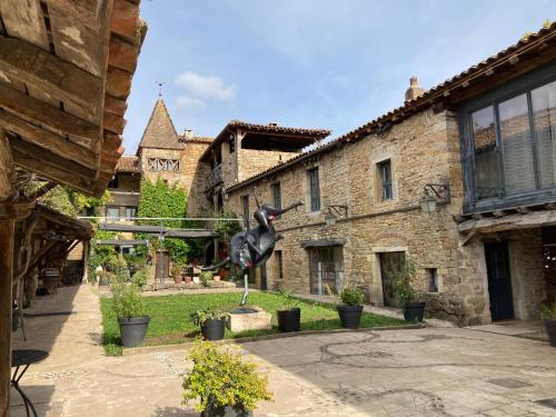 a statue of a horse in a courtyard of a building at Art'Hotel & SPA Le Potin Gourmand in Cluny