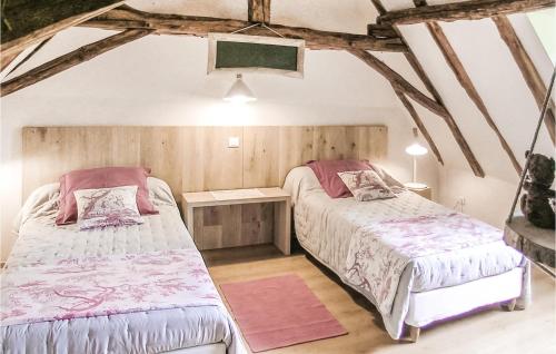 two beds in a room with wooden walls at Nice Home In Fleurac With 3 Bedrooms, Outdoor Swimming Pool And Swimming Pool in Fleurac