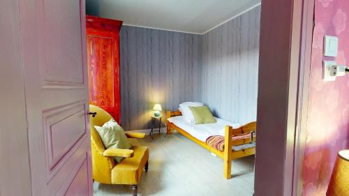 a small bedroom with a bed and a chair at La maison Blanche - Issenheim in Issenheim