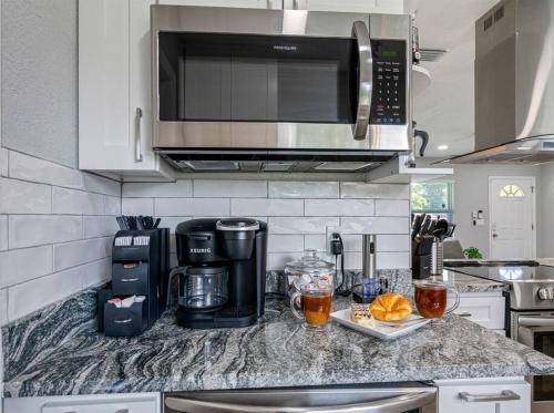 a kitchen counter with a coffee maker and a microwave at Charming & Renovated Home 20 Minutes from Tampa in Brandon