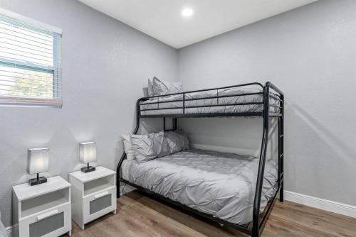 a bedroom with a bunk bed and two night stands at Charming & Renovated Home 20 Minutes from Tampa in Brandon