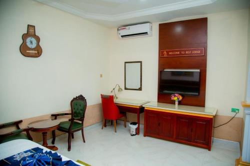 a room with a bed and a desk and a table at Best Lodge in Tamale