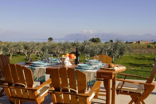 a table with chairs and a table with fruit on it at Villa delle Stelle in Scopello