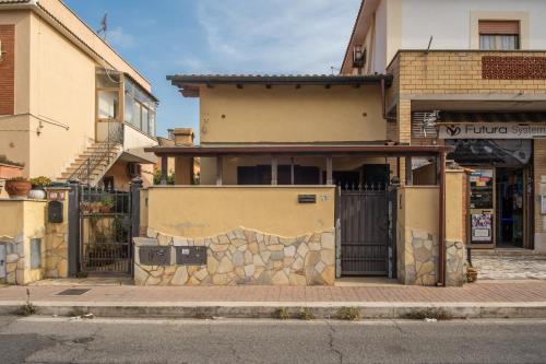 a house with a gate in front of a building at BLOSSOM GARDEN - free parking in Passoscuro