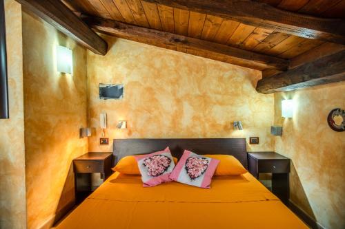 una camera con letto arancione e 2 cuscini rosa di BLOSSOM GARDEN - free parking a Passoscuro