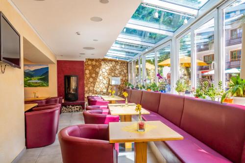 フェルト・アム・ゼーにあるHotel Alte Postの紫色の椅子とテーブル、窓のあるレストラン