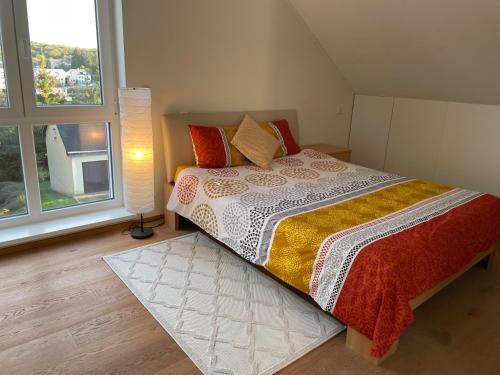 a bedroom with a large bed and two windows at Vakantie appartement in Luxemburg in Berbourg