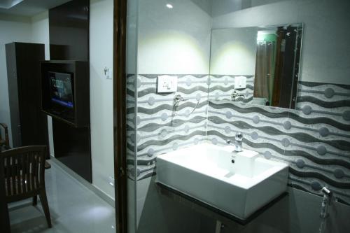 a bathroom with a sink and a mirror at KVP Inn in Tirupati