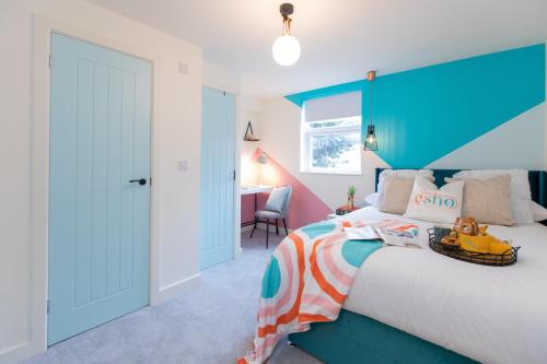 a bedroom with a large bed with a blue headboard at 5 bed 5 bath house, free parking, patio garden - Esho Stays in Coventry