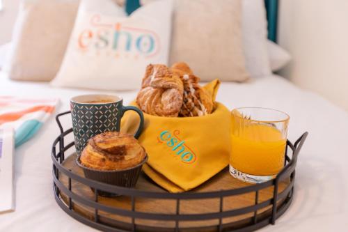 a basket of pastries and a glass of orange juice at 5 bed 5 bath house, free parking, patio garden - Esho Stays in Coventry