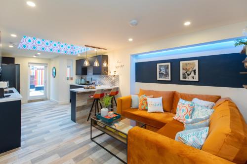 a living room with a couch and a kitchen at 5 bed 5 bath house, free parking, patio garden - Esho Stays in Coventry