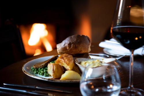 a plate of food on a table with a glass of wine at High Force Hotel in Newbiggin