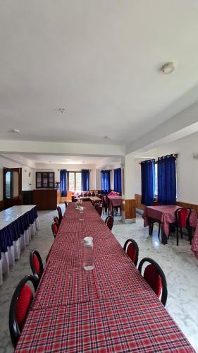 a long table in a room with tables and chairs at Hotel Himsagar in Pemayangtse