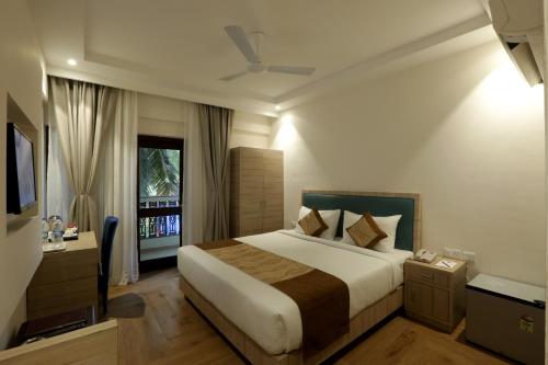 a bedroom with a large bed and a window at Le Seasons Resort in Candolim