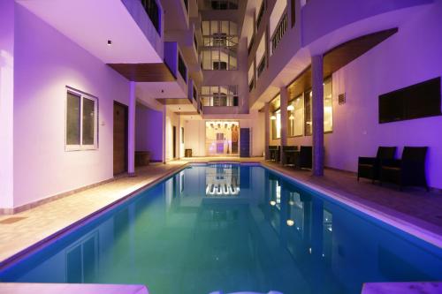a large swimming pool in a building with purple lighting at Le Seasons Resort in Candolim