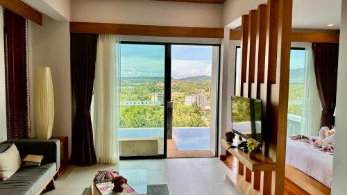 a bedroom with a large glass door leading to a balcony at Aonang Phu Dahla Private Pool & Sea View - SHA Plus in Ao Nang Beach