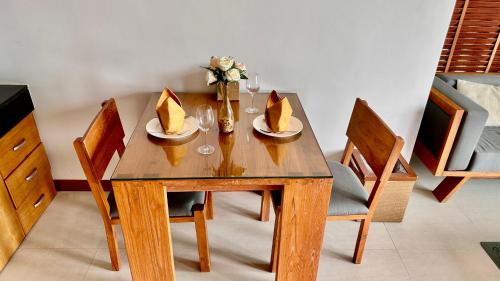 a wooden table with two plates and a vase with flowers at Aonang Phu Dahla Private Pool & Sea View - SHA Plus in Ao Nang Beach