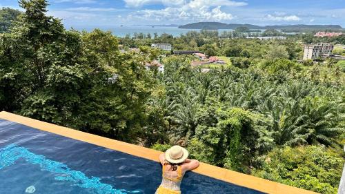 a woman standing on the edge of a swimming pool at Aonang Phu Dahla Private Pool & Sea View - SHA Plus in Ao Nang Beach