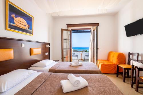 ein Hotelzimmer mit zwei Betten und Balkon in der Unterkunft Irini Hotel in Afiartis