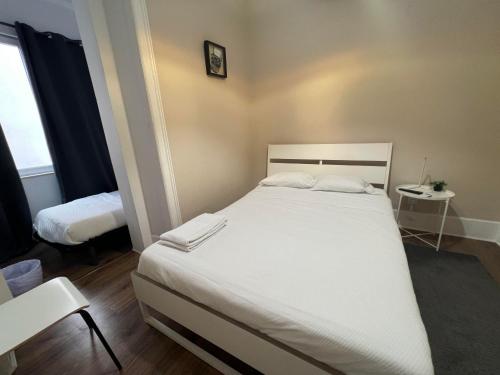 a bedroom with a large white bed and a table at Suites & Apartments DP VFXira in Vila Franca de Xira