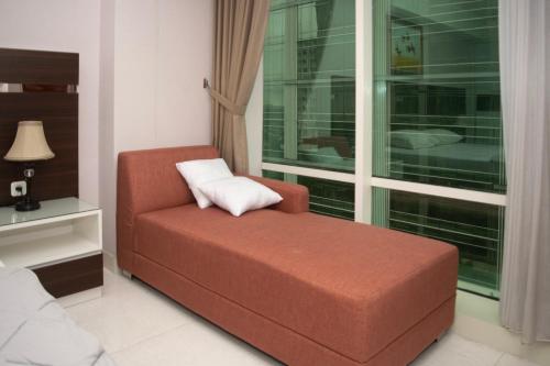 a living room with a chair and a window at The Cabin Mataram City in Kejayan