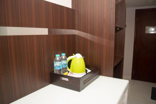 a bathroom with a yellow tea pot and water bottles at The Cabin Mataram City in Kejayan