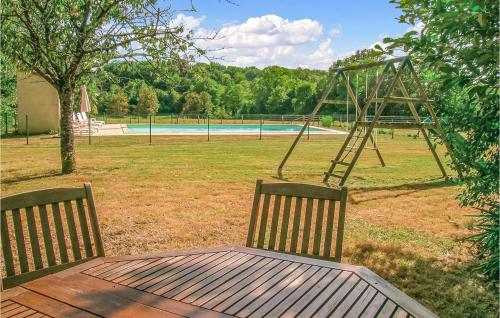 a picnic table with two chairs and a swing at Stunning Home In St Maixent De Beugné in Saint-Maixent-de-Beugné