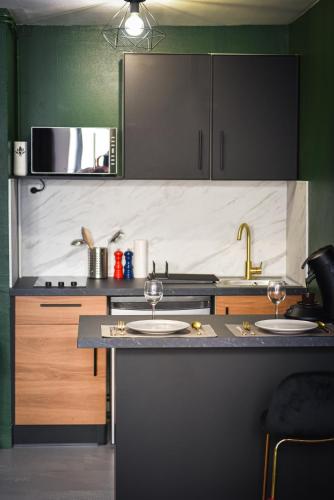 - une cuisine avec 2 verres à vin sur un comptoir dans l'établissement Spa & Detente - Cinéma - Netflix - Hyper Centre, à Arras