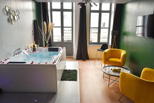 a living room with a hot tub and a yellow chair at Spa & Detente - Cinéma - Netflix - Hyper Centre in Arras
