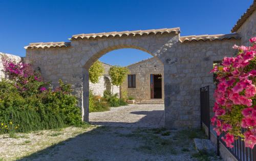 une entrée à une maison en pierre avec une arche dans l'établissement Borgo Monachella, à Raguse