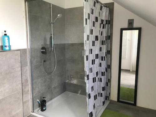 a bathroom with a shower with a shower curtain at Vakantie appartement in Luxemburg in Berbourg