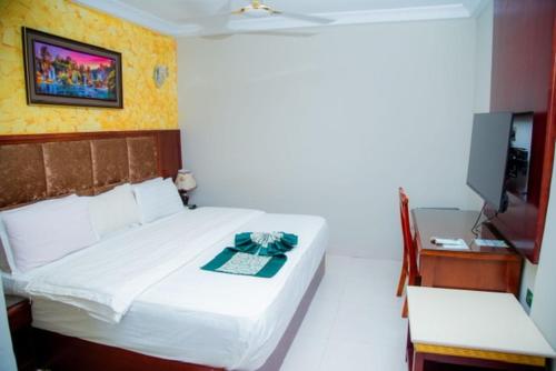 a bedroom with a bed and a desk and a television at Best Lodge in Tamale