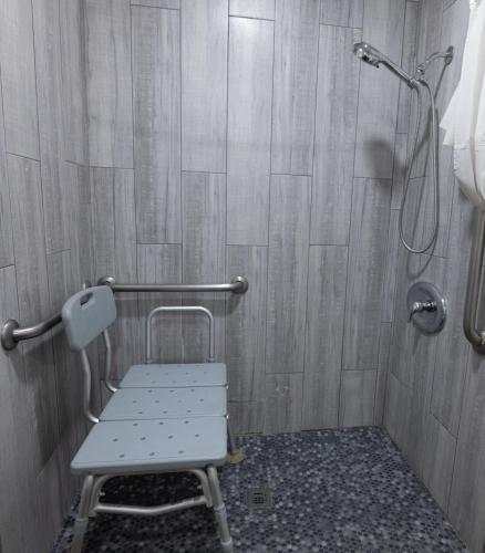 a shower with a bench in a bathroom at Hospitality Inn in San Bernardino