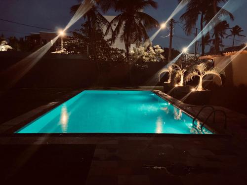 ein Schwimmbad in der Nacht mit Lichtern in der Unterkunft Outro Beach Hotel Cumbuco in Cumbuco