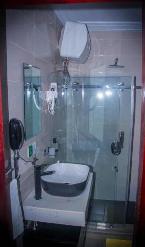 a bathroom with a sink and a glass shower at Best Lodge in Tamale