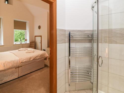 a bedroom with a bed and a glass shower at On the Straits in Menai Bridge