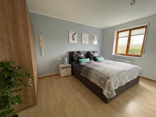 een slaapkamer met een bed en een raam bij Schwarzwald - Schöne, ruhige Auszeit in der FeWo - Im Grünen in Weilheim