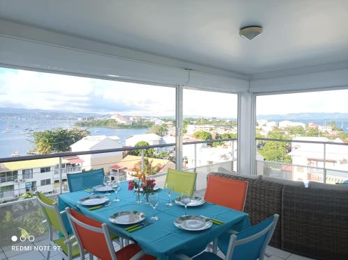une salle à manger avec une table bleue et des chaises colorées dans l'établissement Appartement Ti Bato, à Les Trois-Îlets
