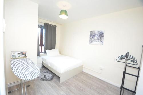 ein kleines Zimmer mit einem Bett und einem Stuhl in der Unterkunft Lovely 4 bedroom apartment close to the city walking distance from the rivere view in London