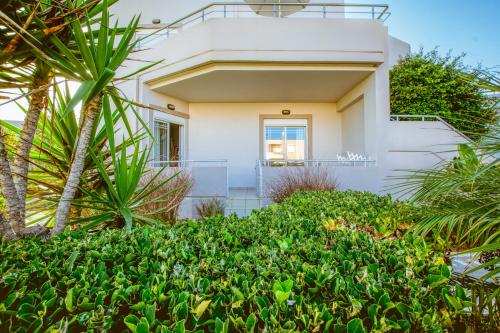 a house with a balcony and palm trees at Gelina Apartments in Plataniás