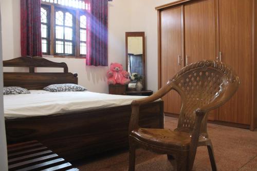 a bedroom with a bed and a chair in it at Holiday Home Anuradapura in Anuradhapura