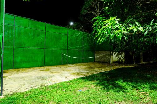 a green fence with a net in a yard at night at Savenndra Resorts in Malwana