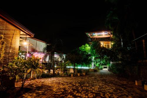 a cobblestone street at night with buildings and trees at Savenndra Resorts in Malwana